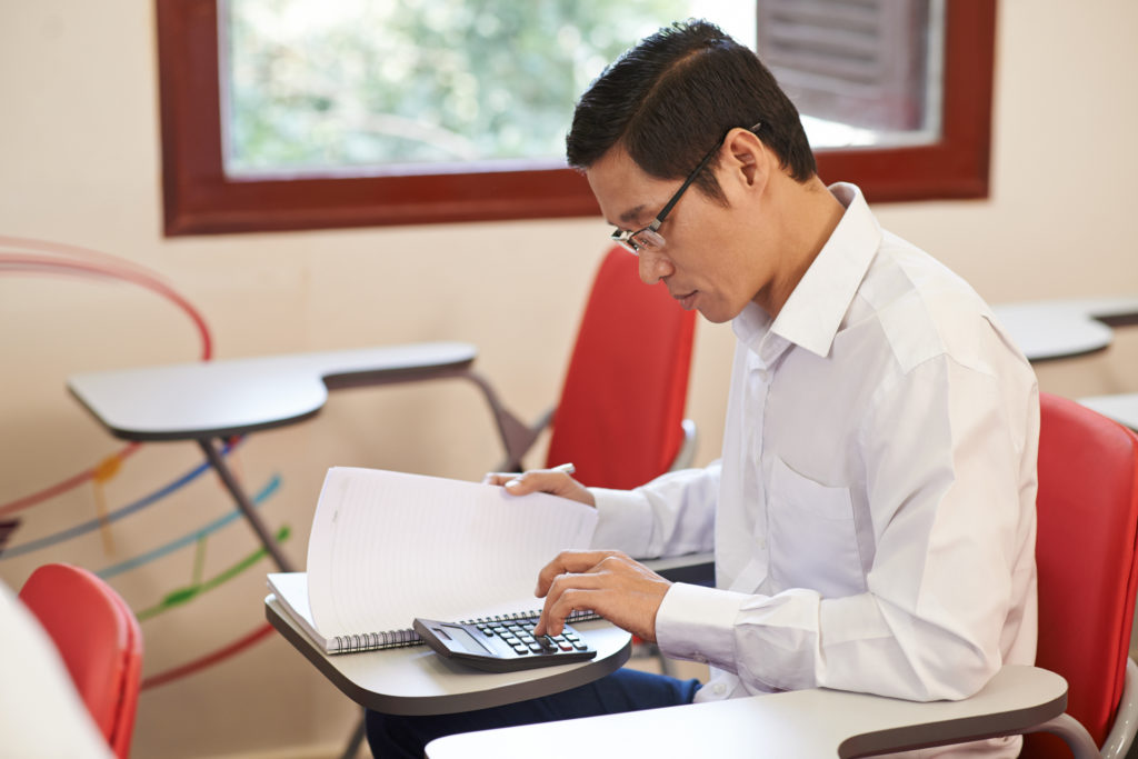 Vietnamese adult student making calculations in the class
