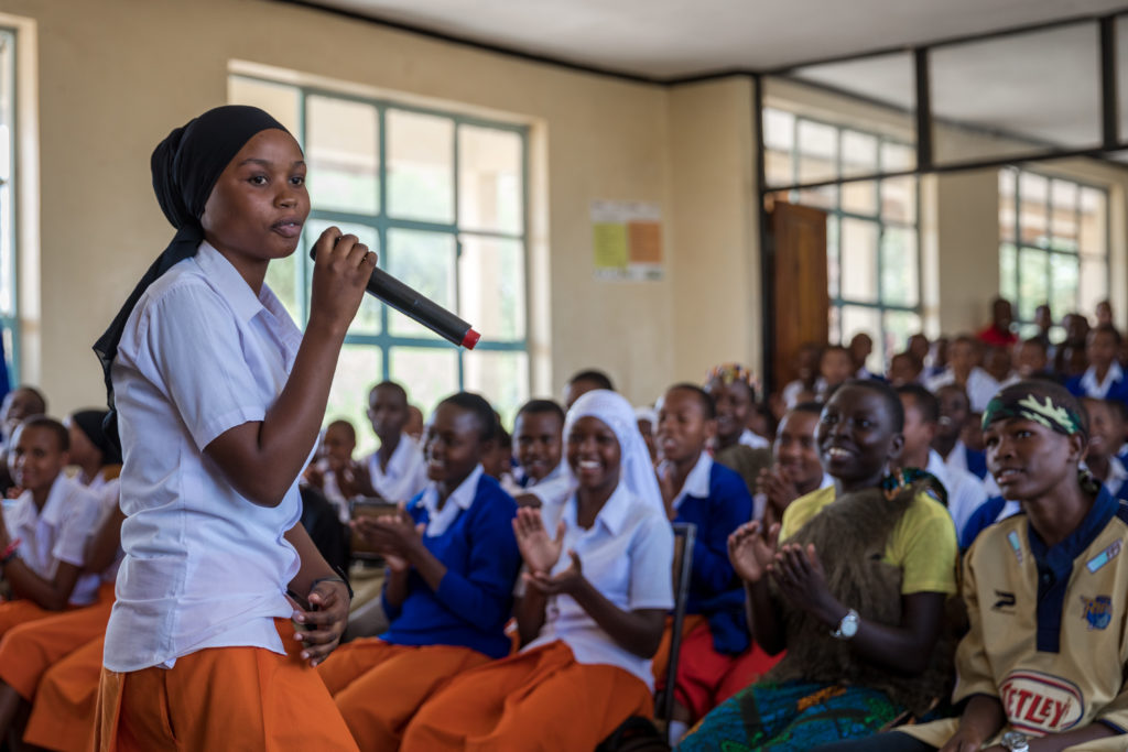 African adolescent girl speaking infront of crowd